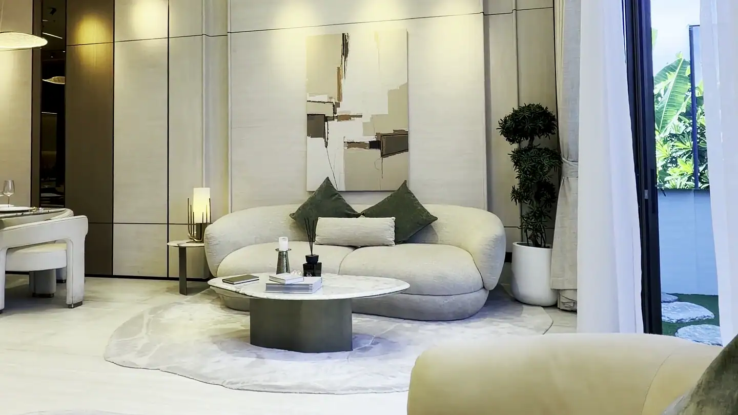 Šviesi svetainė su lenkta sofa ir pakabinamais šviestuvais